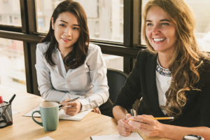 白人女性とアジア人女性が企業で働いている写真