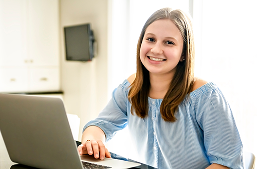 White woman working remotely on computer