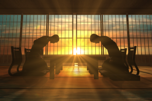 Two silhouettes bowing to each other in front of a sunset in a Japanese environment